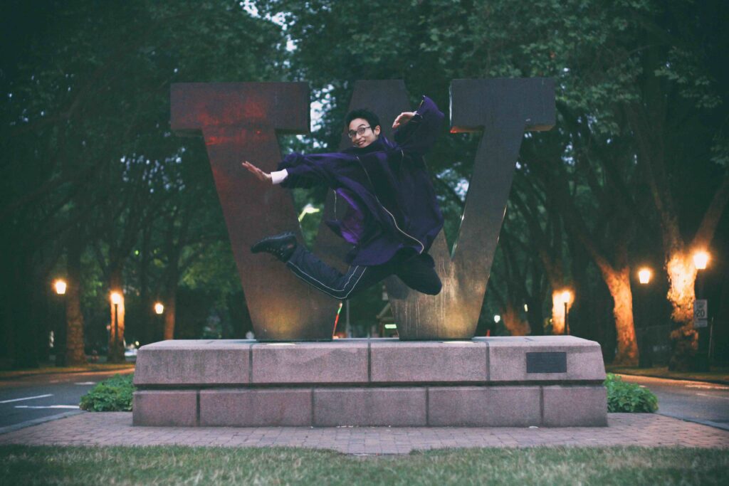 Student jumping in graduation regalia