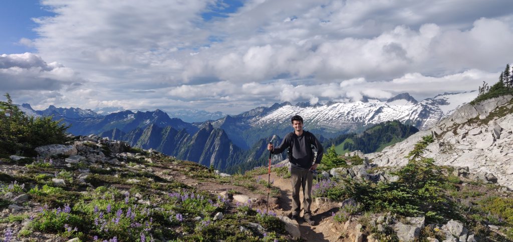 Moeez surrounded by wild flowers and snowy mountains. 