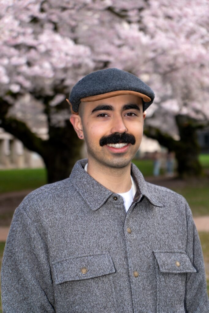 Daniel Mendoza standing in front of cherry blossom trees.